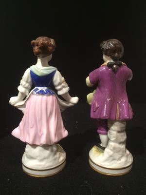 A Pair of Boy Girl Figurines with a 3 loops crown mark with a cross on top and two Gs one a backtofront mirror G
