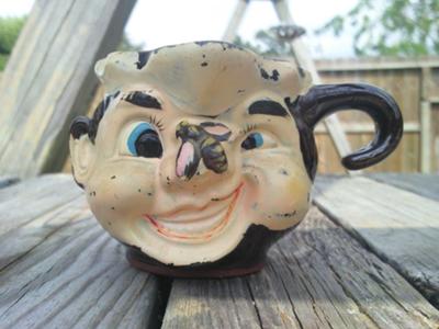 Character mug with a gold N inside a gold circle