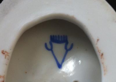 marked with a pair of pitch forks formed into a V with a comb on top