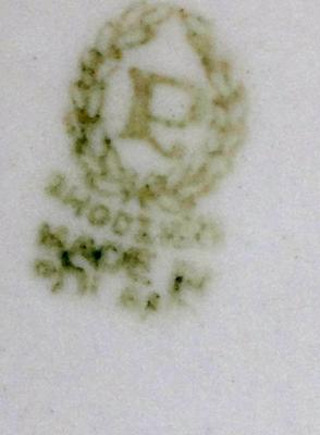 P OR R in a Wreath Marking on a red vase with white flowers