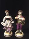 A Pair of Boy Girl Figurines with a 3 loops crown mark with a cross on top and two Gs one a backtofront mirror G